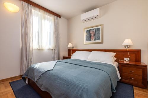 a bedroom with a large bed and a window at BELLAVISTA apartman Punta in Veli Lošinj