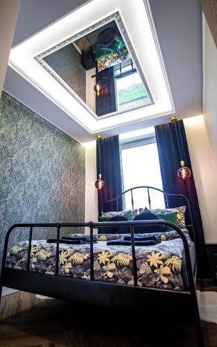 a bedroom with a bed with a mirror on the ceiling at Apartament „Nad Ratuszem” in Częstochowa