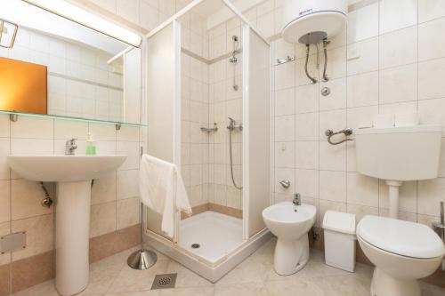 a bathroom with a shower and a toilet and a sink at BELLAVISTA apartman Punta in Veli Lošinj