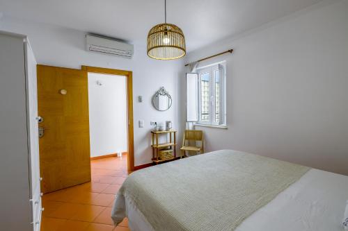 Schlafzimmer mit einem Bett, einem Fenster und einem Tisch in der Unterkunft Casa Luma B&B in Lagos