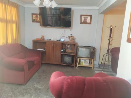 sala de estar con sofá y TV en Casa Abuelito's Andean Haven, en Huaraz