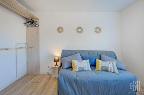 een blauw bed met kussens in een kamer bij La Halte 1 in Veigné