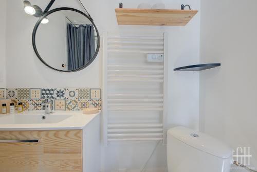 a bathroom with a sink and a mirror and a toilet at La Halte 1 in Veigné