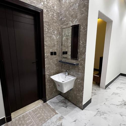 a bathroom with a sink and a mirror at شقة فاخرة بغرفة نوم وصالة 10 Luxury APT in Riyadh