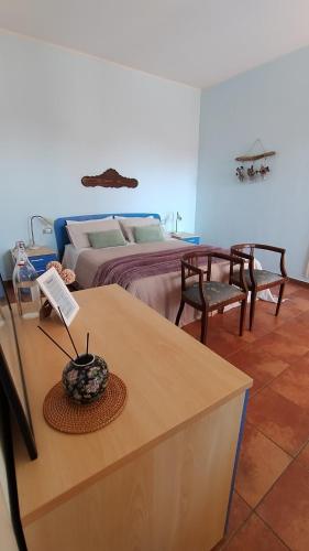 1 dormitorio con 1 cama, mesa y sillas en La Locanda di Campagna a Guardabosone 