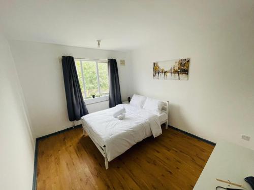 a bedroom with a white bed and a window at Double Room near Canary Wharf 32 in London