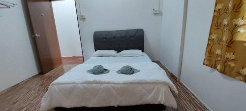 Un dormitorio con una cama con dos sombreros. en EverGreen Lodge Bed & Breakfast, en Sukau