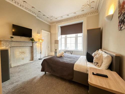 a bedroom with a large bed and a fireplace at City Centre 5 Bedroom Flat on Sauchiehall Street in Glasgow