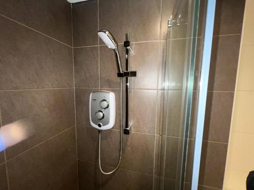 a shower with a shower head in a bathroom at City Centre 5 Bedroom Flat on Sauchiehall Street in Glasgow