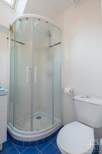 une salle de bain avec une douche en verre et des toilettes dans l'établissement Le Michelet - Gare à 500 m, à Tours