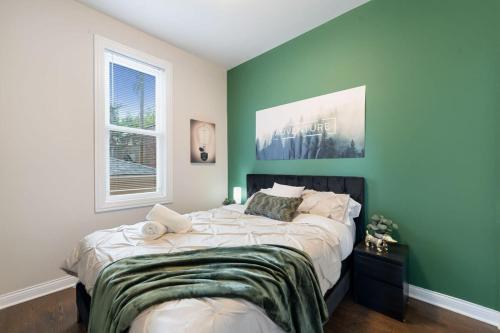 um quarto com uma cama grande e paredes verdes em Stylish 2 BDR Coach House Steps From The Lake em Chicago