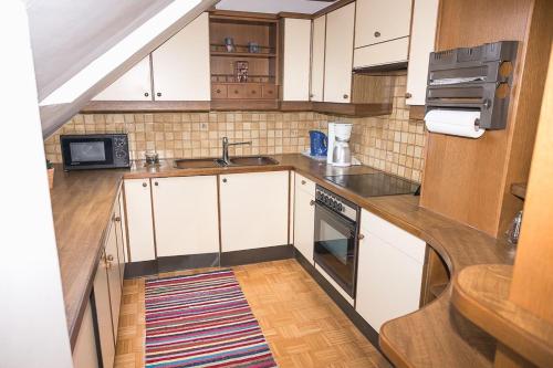 a small kitchen with white cabinets and a sink at Ferienwohnung Rebekka in Riedlingsdorf