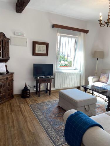 a living room with a couch and a tv at PLENO CENTRO COMILLLAS-3 Hab, 2 Baños in Comillas