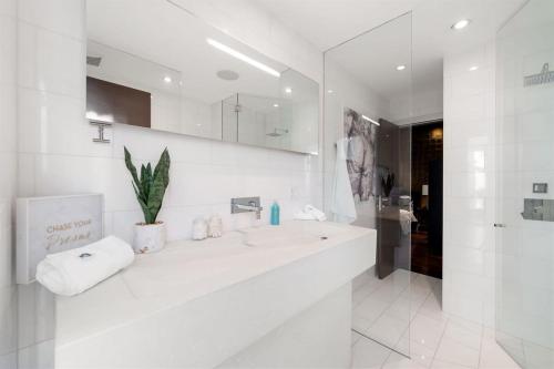 een witte badkamer met een wastafel en een spiegel bij 5BR 5BA Architectural Estate-Theatre Gym Rooftop in Chicago