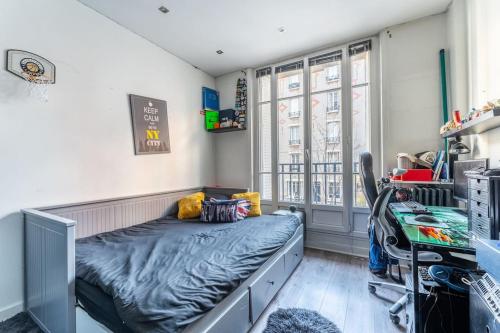 een slaapkamer met een bed en een bureau in een kamer bij luxueux appartement haussmannien in Saint-Mandé