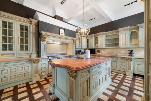 a large kitchen with white cabinets and a large island at 5BR 5BA Architectural Estate-Theatre Gym Rooftop in Chicago