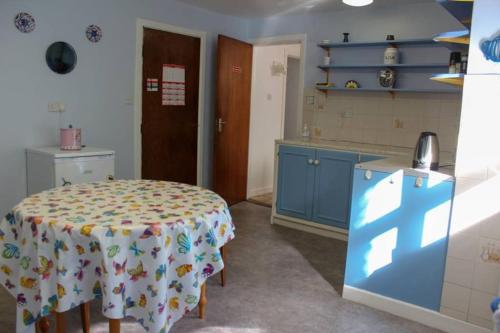 a kitchen with a table and blue cabinets at Katie's Town House in Cahersiveen