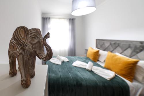 Una habitación con una cama con un elefante de madera. en Quartos da Tia Laura en Nazaré
