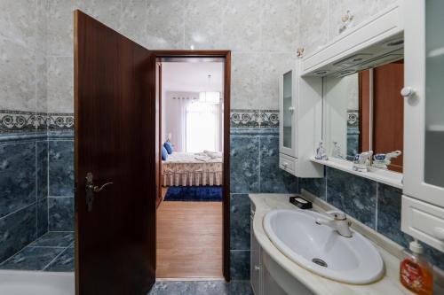 y baño con lavabo y espejo. en Quartos da Tia Laura en Nazaré