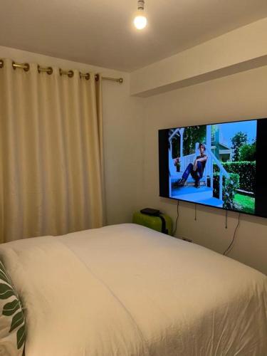 a bedroom with a bed and a flat screen tv at STARS LUXURY HOME in London