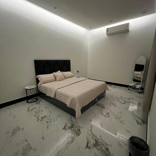 a bedroom with a bed and a marble floor at شقة فاخرة بغرفة نوم وصالة 10 Luxury APT in Riyadh