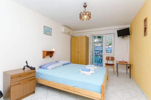 ein Schlafzimmer mit einem Bett, einem Schreibtisch und einem Stuhl in der Unterkunft Studio Apartments Klara and Rio in Stomorska