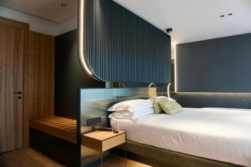 a bedroom with a large white bed and a mirror at Hotel Ristorante Al Caminetto WorldHotels Crafted Adults Only in Torri del Benaco