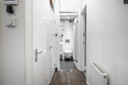 a corridor of a bathroom with a toilet in it at Livestay-Charming London Retreat Stylish 1BR near Kings Cross&Farrington in London