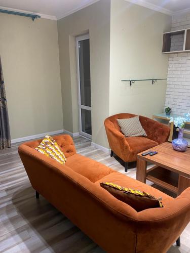 ein Wohnzimmer mit einem Sofa und einem Tisch in der Unterkunft Khoroolol studio apartment in Ulaanbaatar