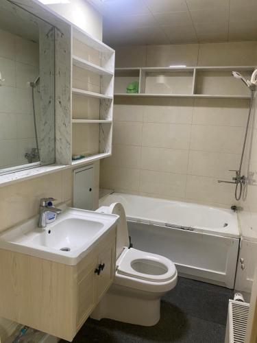 ein Badezimmer mit einem Waschbecken, einem WC und einer Badewanne in der Unterkunft Khoroolol studio apartment in Ulaanbaatar