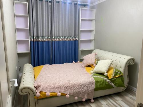ein Kinderschlafzimmer mit einem Bett und Regalen in der Unterkunft Khoroolol studio apartment in Ulaanbaatar