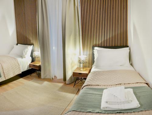 een slaapkamer met twee bedden en twee nachtkastjes bij Minerva Boutique Residence in Rome