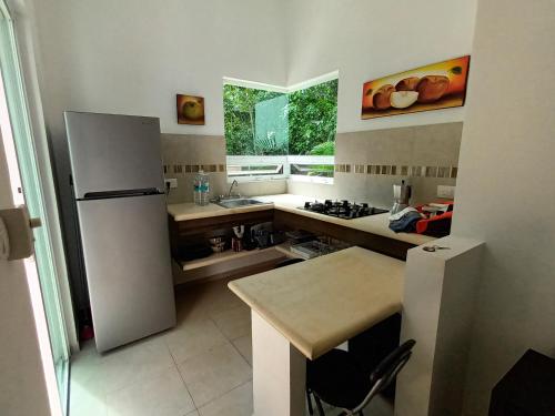 a kitchen with a white refrigerator and a sink at Villa Ixchel private pool in Tulum