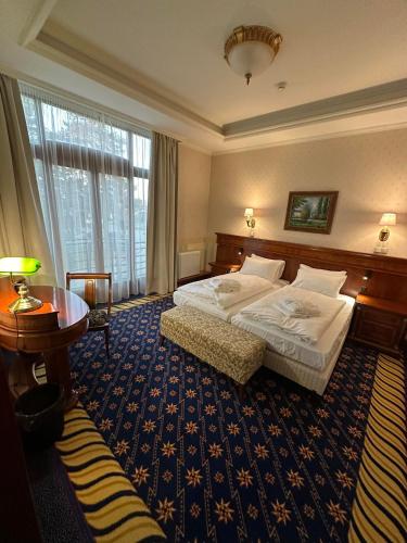 a hotel room with a bed and a table at Hotel Golden Palace in Göd