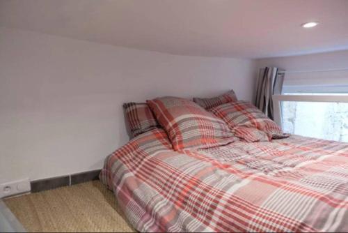 une chambre avec un lit avec une couverture à carreaux dans l'établissement La Courette, Beau studio, Clim, Centre Historique, à Montpellier