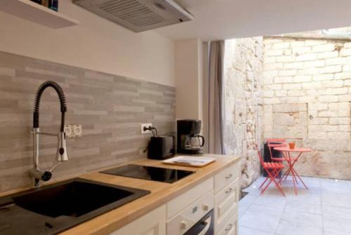 une cuisine avec un évier et un plan de travail dans l'établissement La Courette, Beau studio, Clim, Centre Historique, à Montpellier