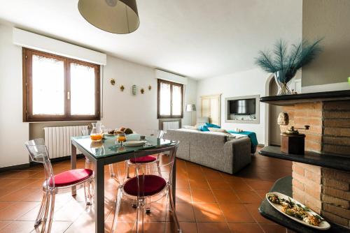 un soggiorno con tavolo, sedie e divano di Hostly - Giusy Garden Suite a Capannoli
