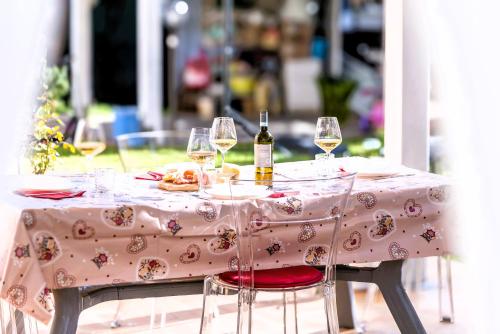 a table with a pink table cloth with wine glasses at Hostly - Giusy Garden Suite - Only for Holidays in Capannoli