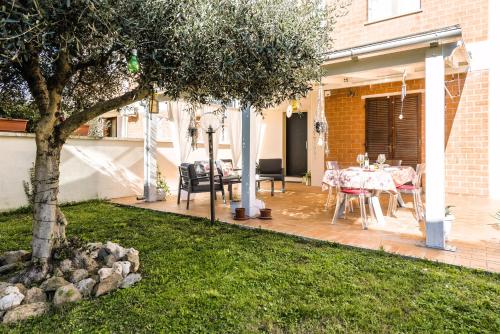 a patio with a table and a tree at Hostly - Giusy Garden Suite - Only for Holidays in Capannoli