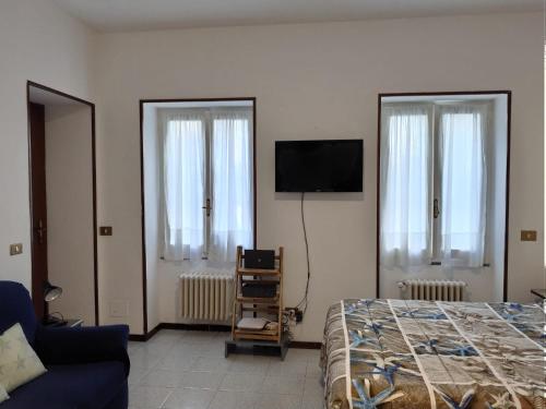 1 dormitorio con 1 cama y TV en la pared en LATTE E MIELE, en Stresa