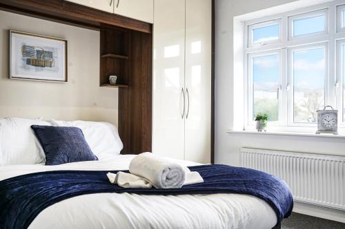 a bedroom with a bed with blue and white towels on it at Spa Shower I 4Bed 3Bath I Sleeps x9 I Parking x2 in Elstree