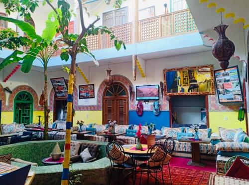 - un salon avec des canapés et un palmier dans l'établissement Riad Dia, à Marrakech