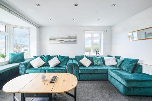 a living room with a green couch and a table at Spa Shower I 4Bed 3Bath I Sleeps x9 I Parking x2 in Elstree