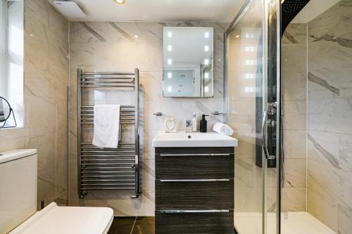 uma casa de banho com um lavatório e um chuveiro em Spa Shower I 4Bed 3Bath I Sleeps x9 I Parking x2 em Elstree