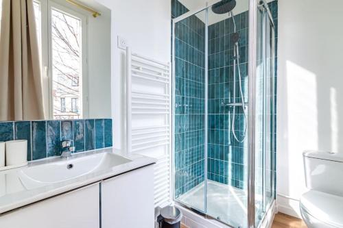 une salle de bain avec une douche en verre et un lavabo dans l'établissement Appartement coloré à 5 minutes de Paris, à Bagnolet