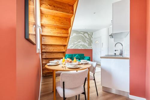 une salle à manger avec une table et des chaises et une cuisine dans l'établissement Appartement coloré à 5 minutes de Paris, à Bagnolet