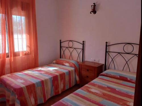 1 dormitorio con 2 camas y ventana en Chalet con piscina privada en Conil Solo Familias, en Conil de la Frontera