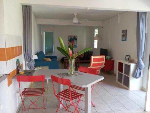 eine Küche und ein Wohnzimmer mit einem Tisch und Stühlen in der Unterkunft Les poinsettias in Les Trois-Îlets