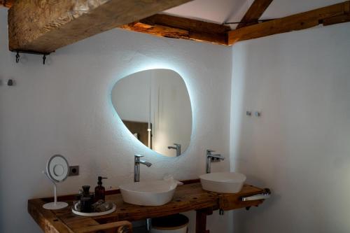 een badkamer met 2 wastafels en een spiegel aan de muur bij Chalet Weidehaus De Luxe 
