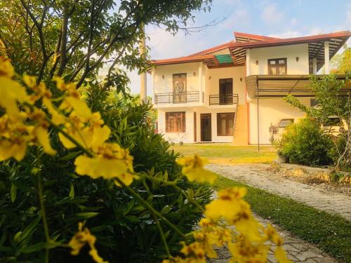 a house with yellow flowers in front of it at SK Villa in Galle